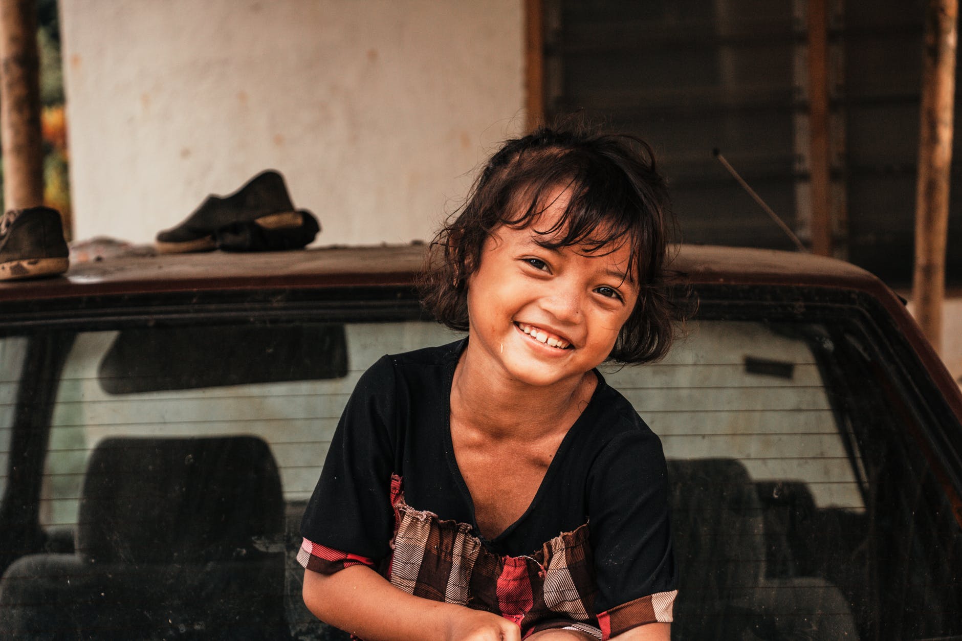 smiling girl sitting top of vehicle